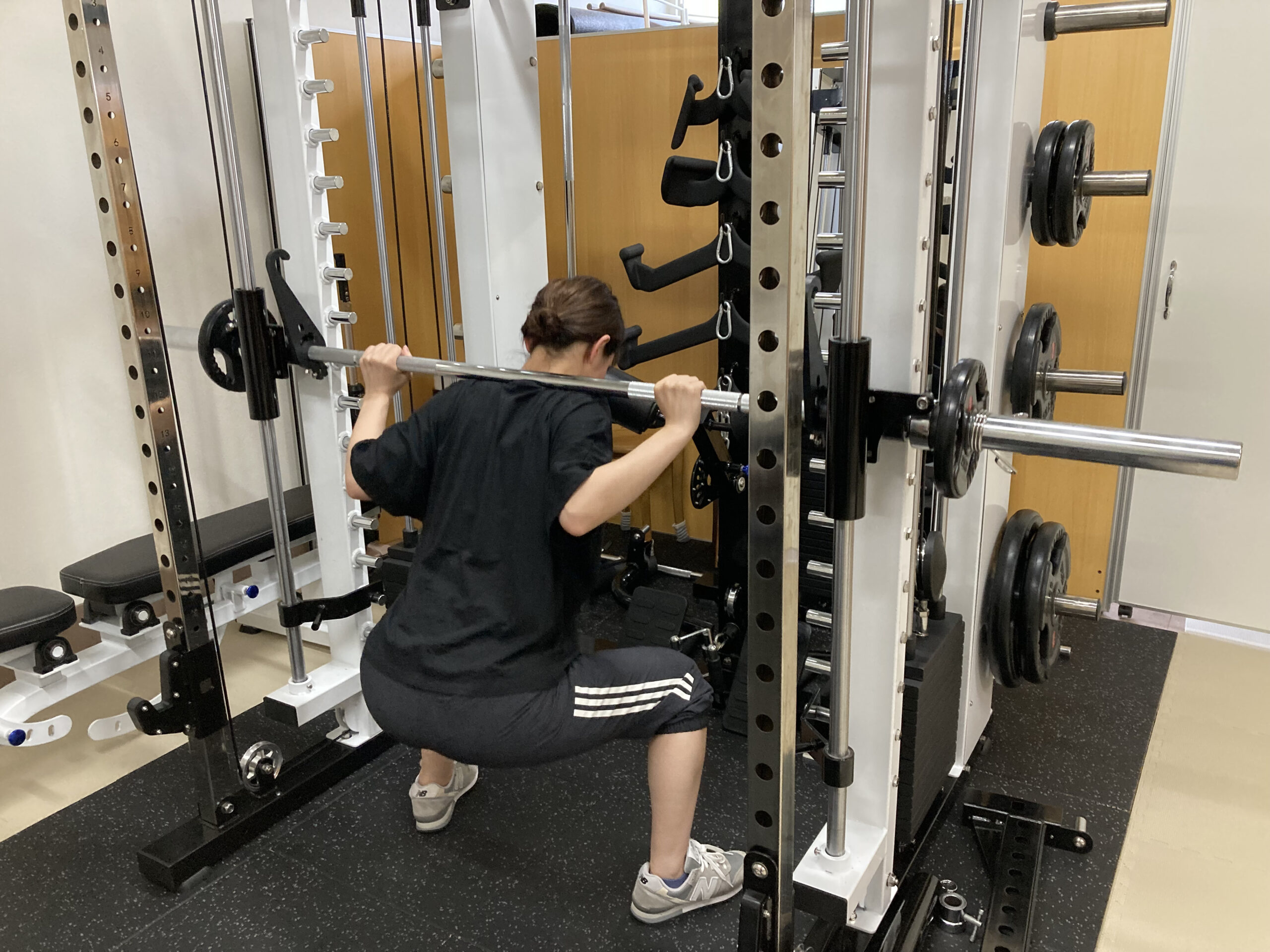 高機能スミスマシンでスクワットをする女性