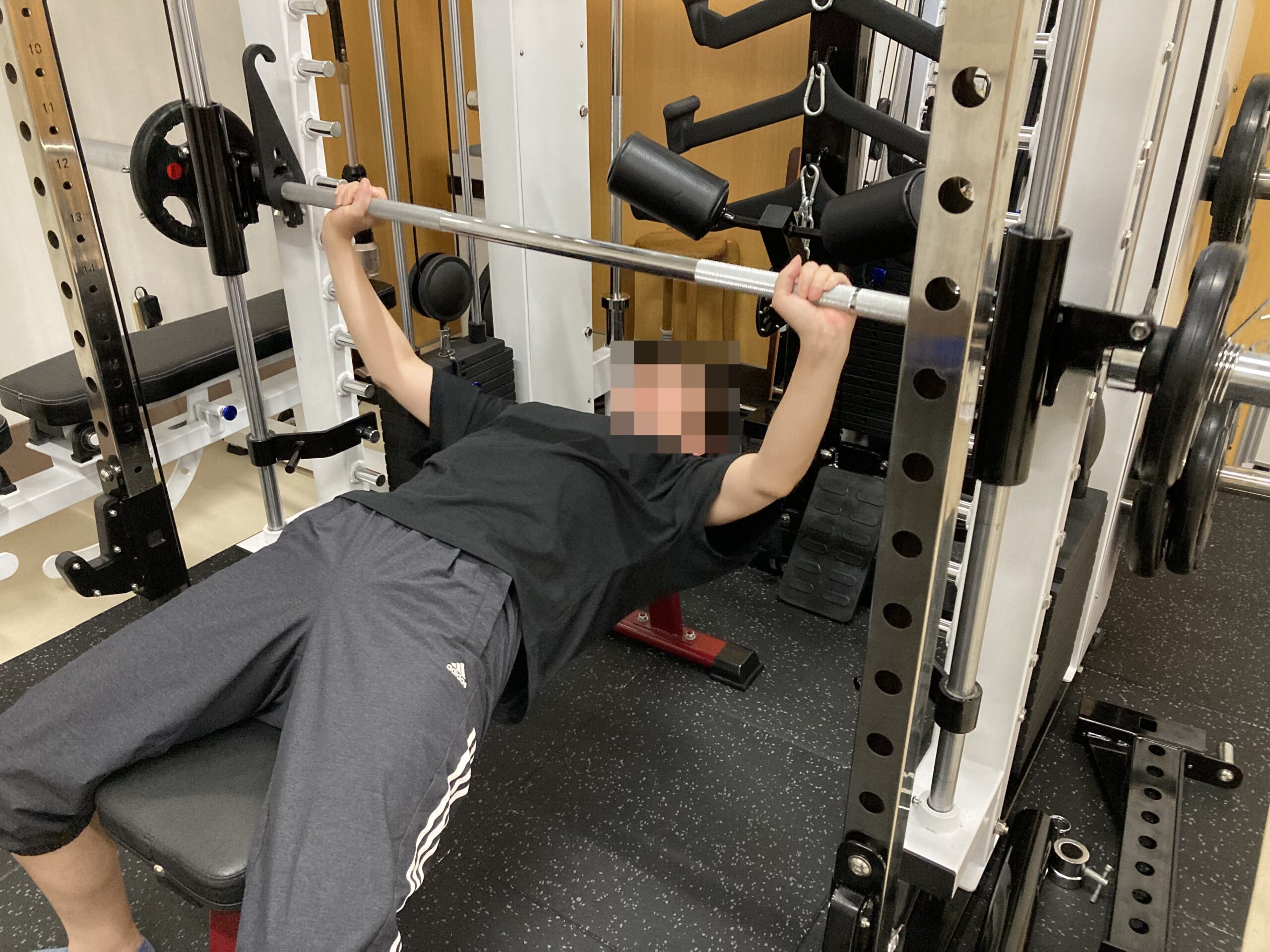 高機能スミスマシンでベンチプレスをあげる女性