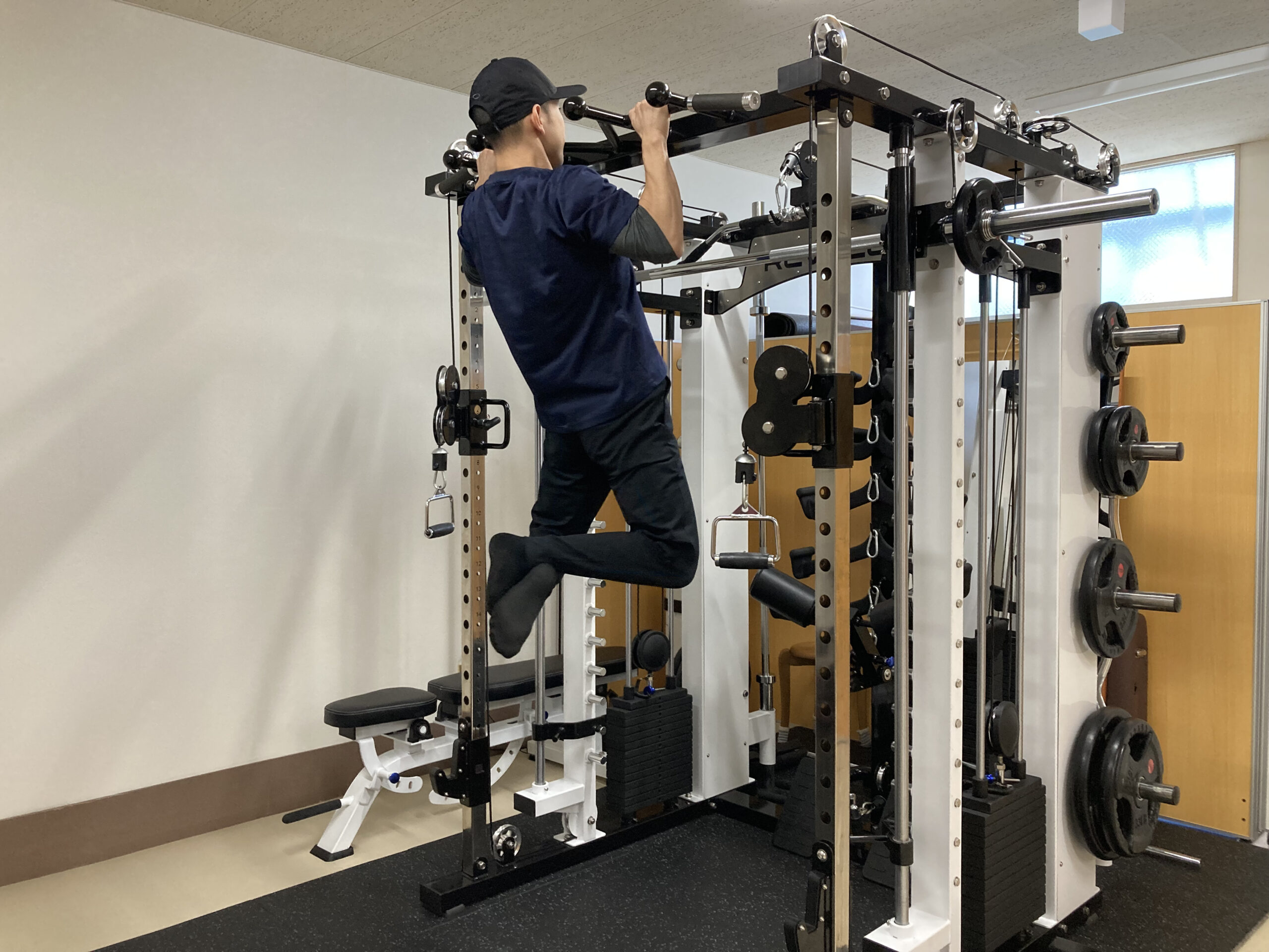 高機能スミスマシンで懸垂をする男性